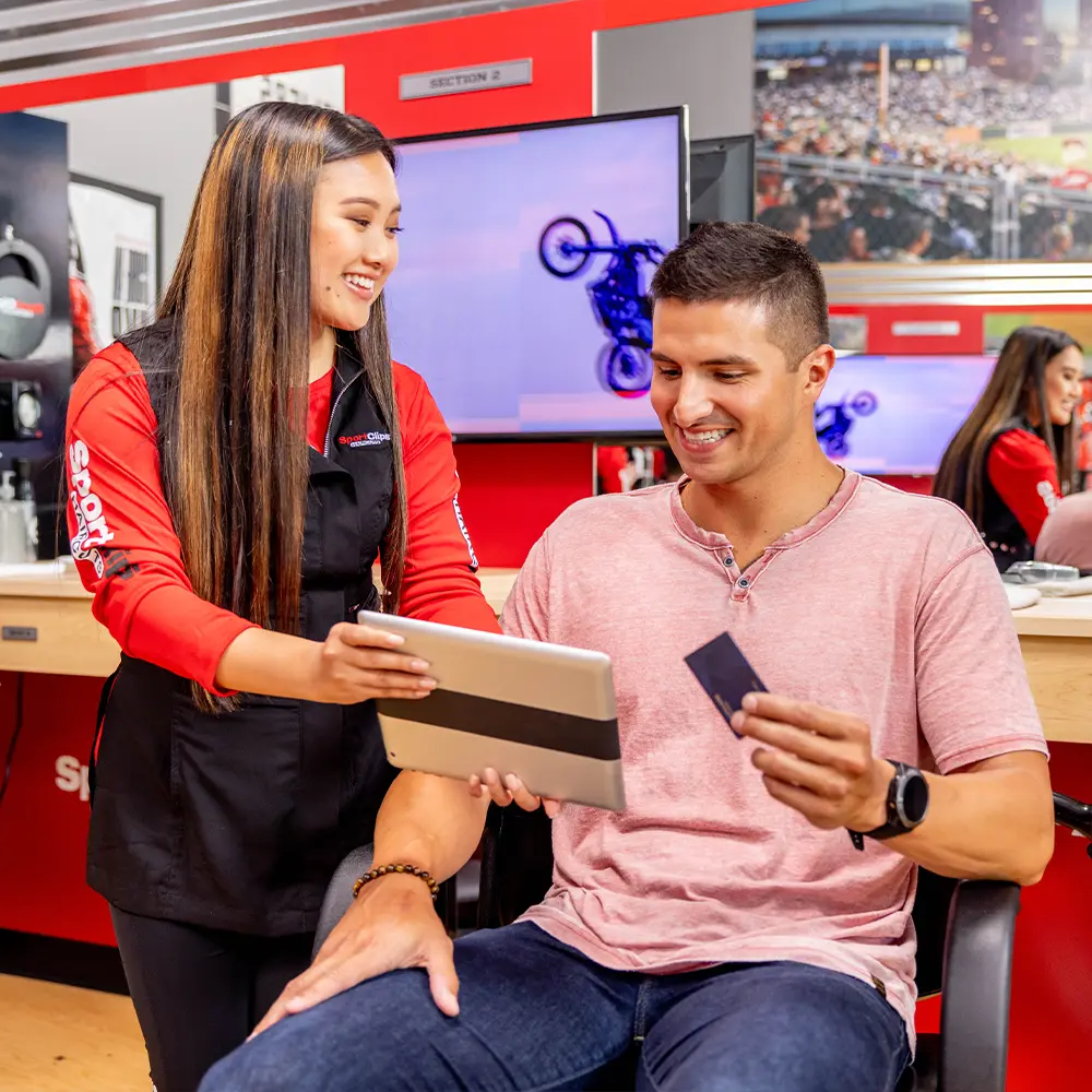 sport-clip-employee-with-ipad customer paying with ipad