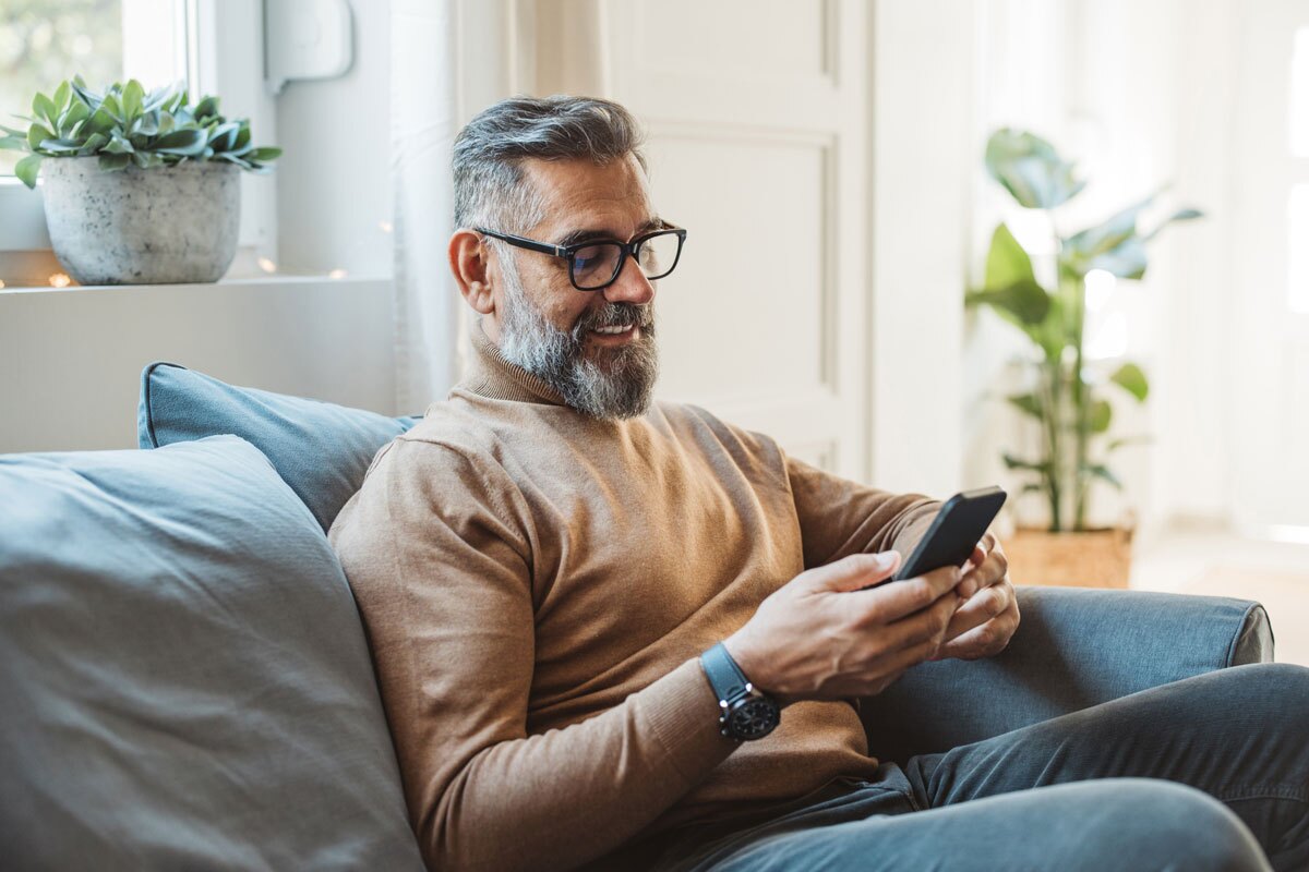 middle aged man on couch with phone